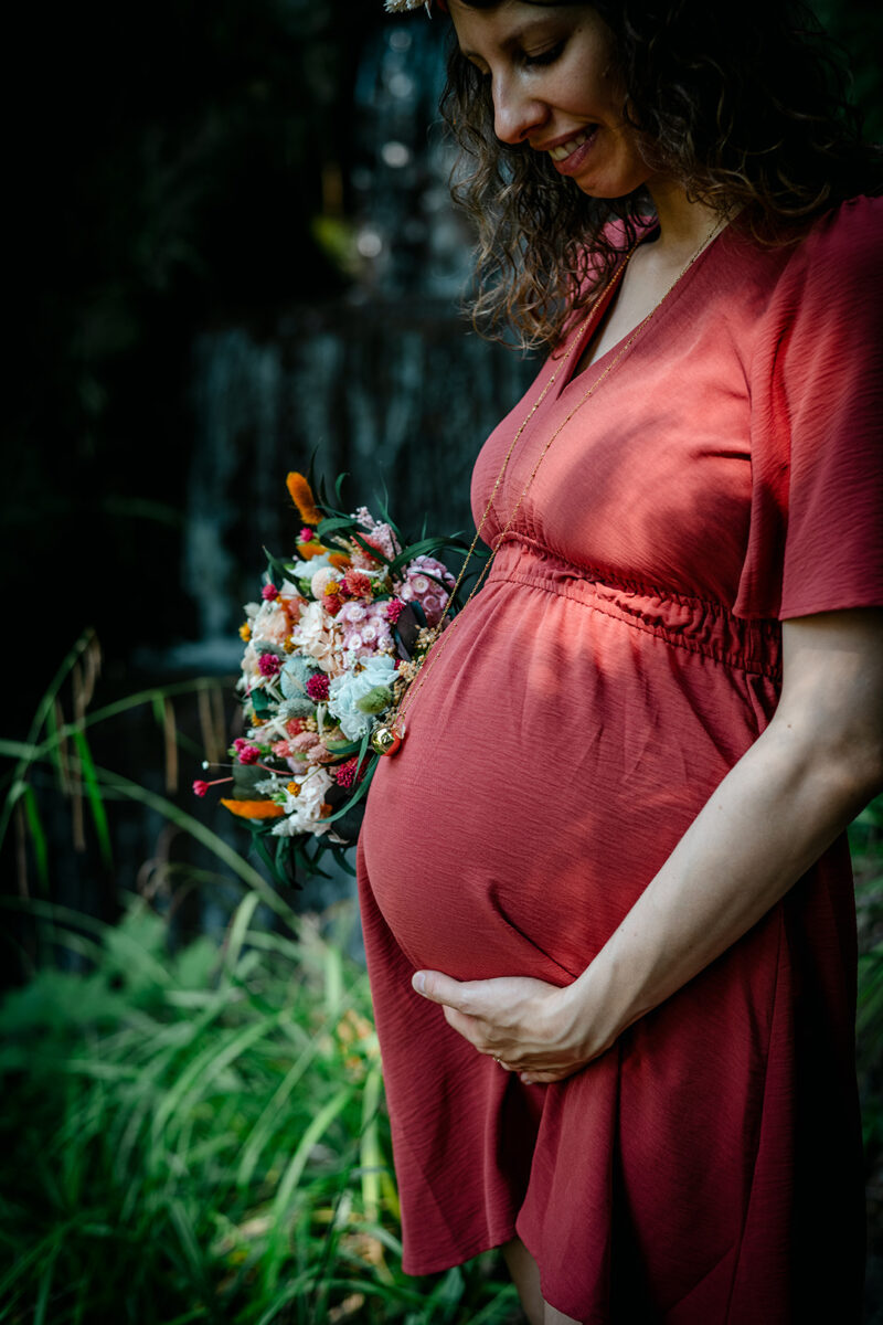 Ventre femme enceinte avec bouquet de fleurs