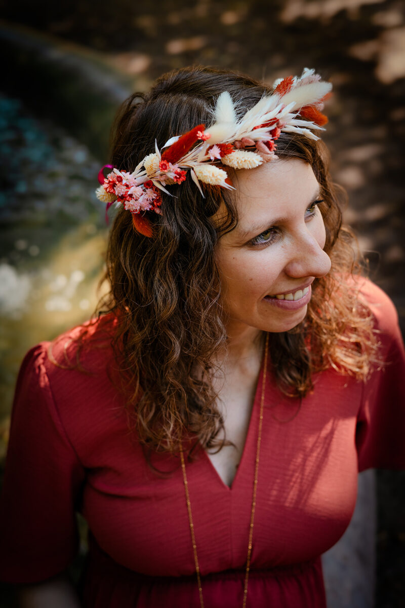 Portrait d'une femme enceinte avec une couronne de fleurs séchées.