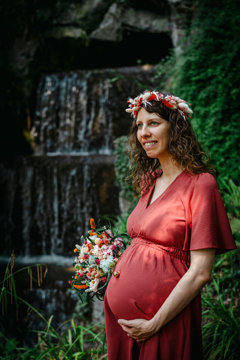 Femme enceinte portant un bouquet et une couronne de fleurs