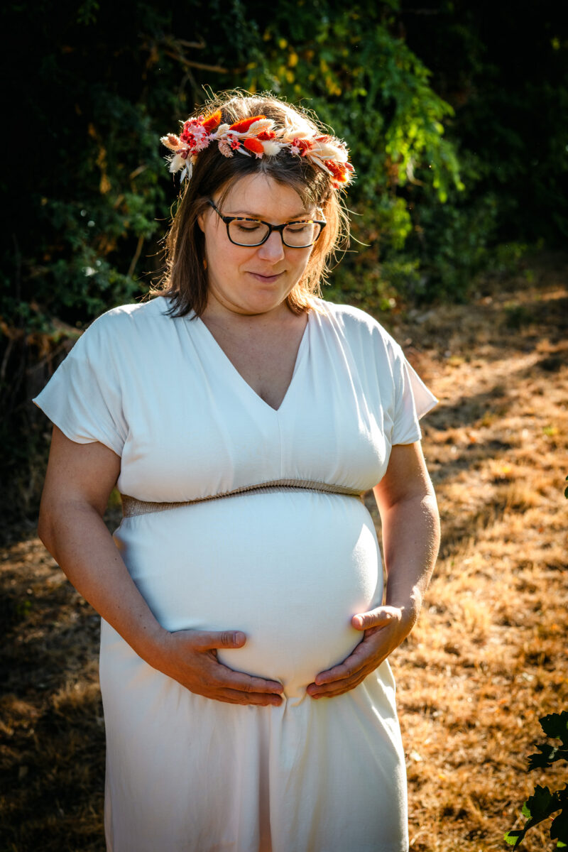 Femme enceinte dans les vignes au lever du soleil.