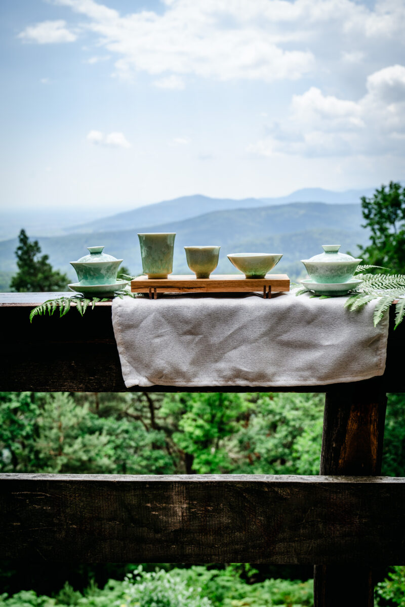 Théières et tasses avec vue sur la montagne pendant séance photo professionnelle